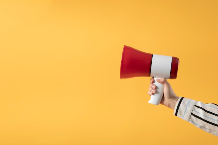 hand holding megaphone with yellow